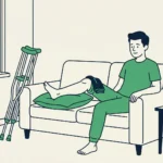 Mann sitzt mit geschwollenem Bein und Kühlpack auf dem Sofa